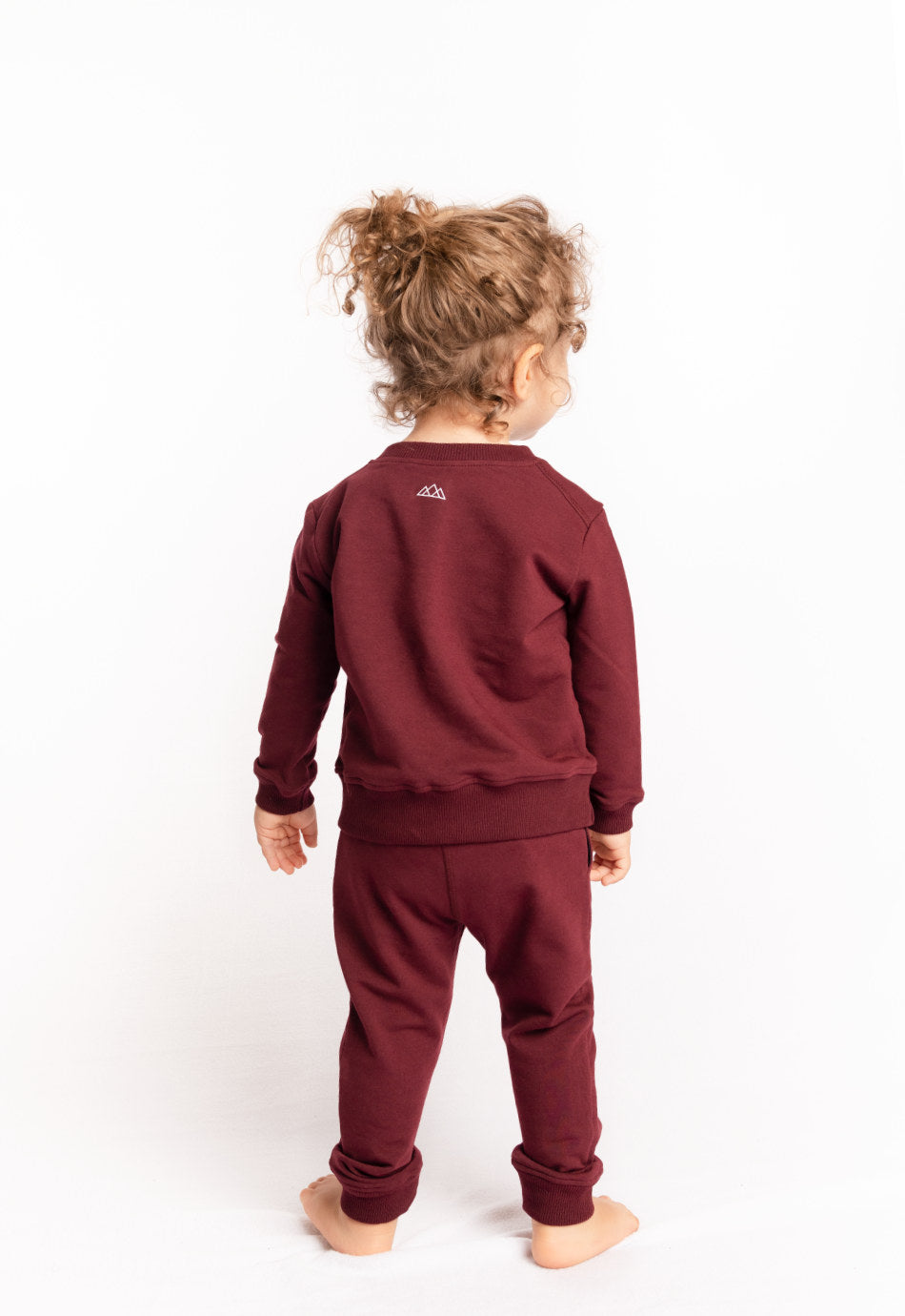 Luke Kinder-Jogginghose in Bordeauxrot aus Bio-Baumwolle mit gerippten Fussbuendchen – nachhaltige und umweltfreundliche Kindermode von M23, Rueckansicht