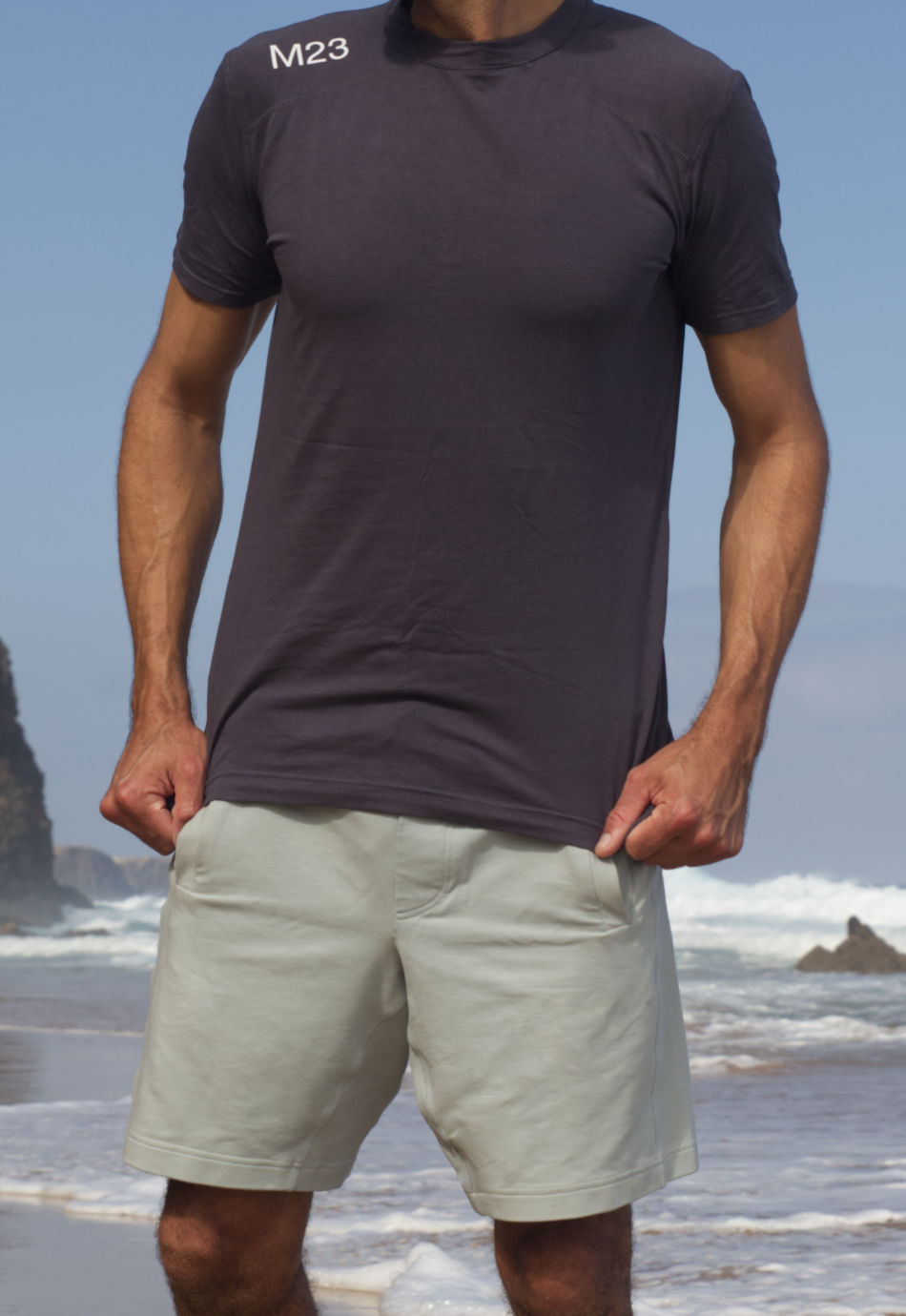 M23 Ben T-Shirt in Anthrazit aus nachhaltiger Bio-Baumwolle, getragen am Strand – atmungsaktives und umweltfreundliches Herren-Shirt.