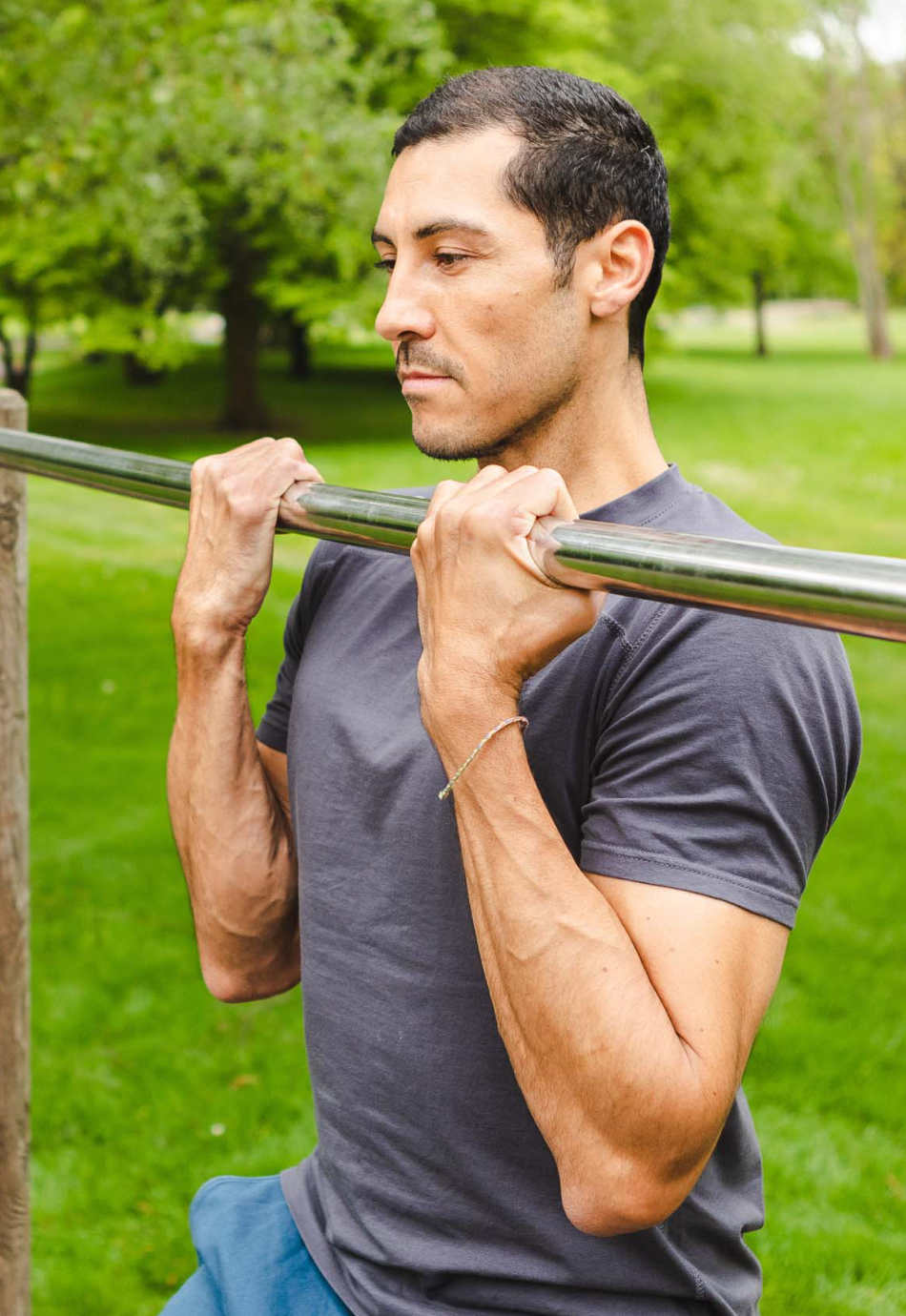 M23 Ben T-Shirt in Anthrazit aus nachhaltiger Bio-Baumwolle, getragen beim Klimmzugtraining im Freien – atmungsaktive und umweltfreundliche Sportmode.
