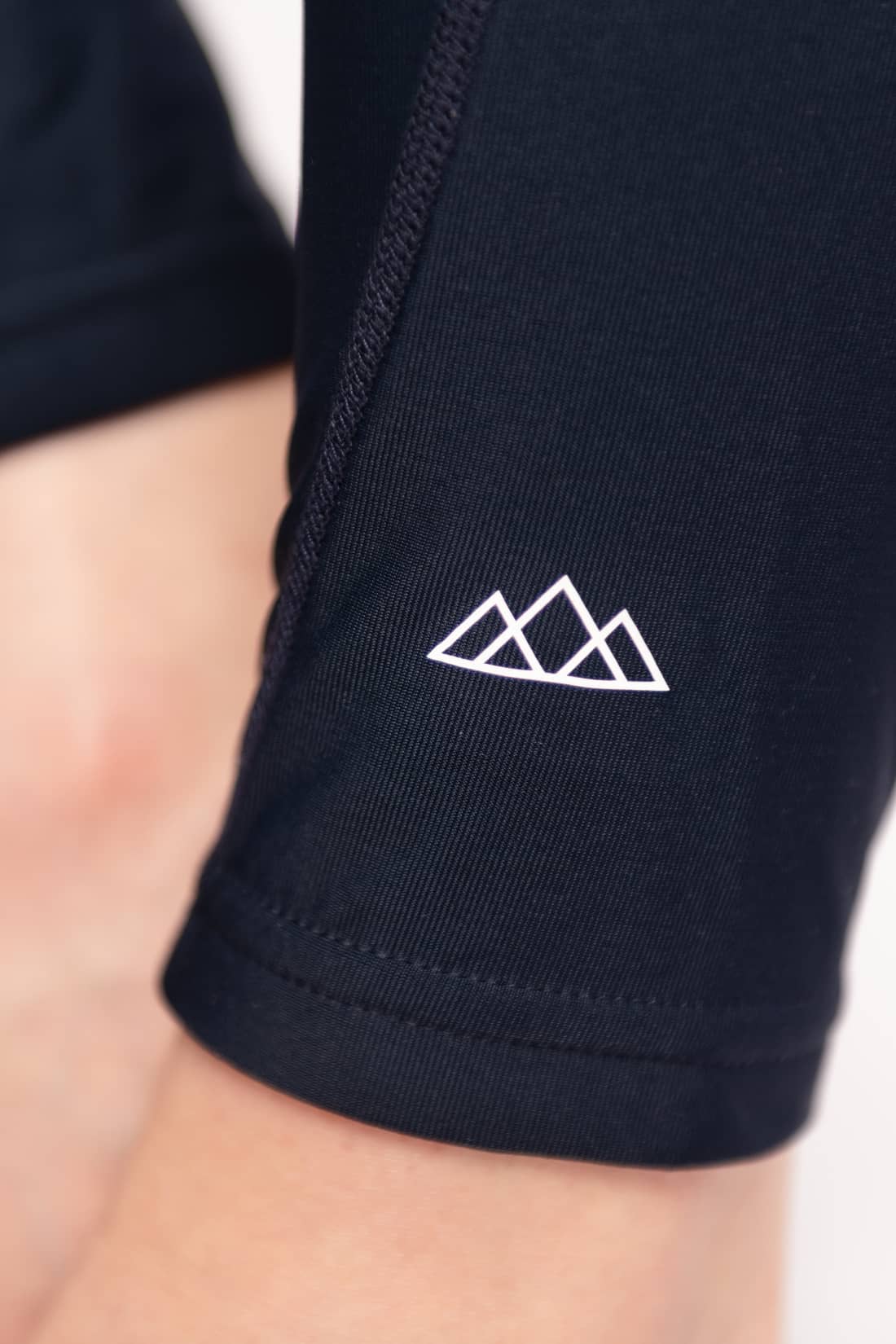 Nahaufnahme der M23 Lina Leggings in Salute-Marineblau mit weißem aufgedrucktem Berg-Logo – hergestellt aus nachhaltiger Bio-Baumwolle fuer umweltfreundliche Damen-Activewear