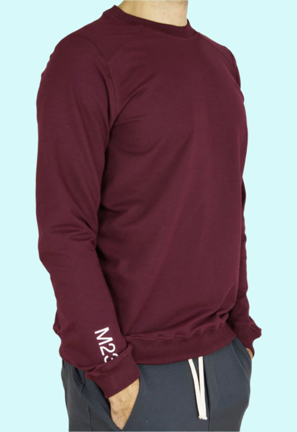 Seitenansicht des M23 Sweatshirts „Phil“ in Bordeauxrot mit weissem M23-Print am Aermel – aus umweltfreundlicher Bio-Baumwolle gefertigt