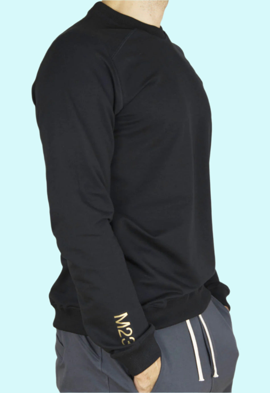 Seitenansicht des schwarzen M23 Sweatshirts „Phil“ mit goldenem M23-Print am Aermel – aus nachhaltiger Bio-Baumwolle, umweltfreundliche Herrenmode.