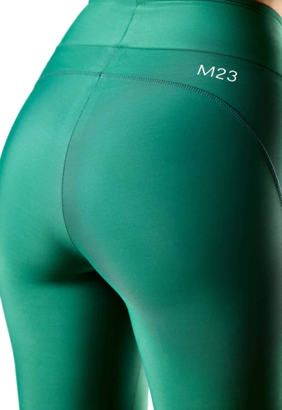 Nahaufnahme der Rueckseite der M23 Lina Leggings in Evergreen-Gruen aus nachhaltiger Bio-Baumwolle – umweltfreundliche, hoch taillierte Passform mit M23 Logo und konturierter Naht
