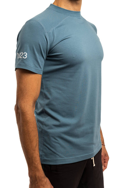 Schraege Seitenansicht des M23 Ben T-Shirts in Blau – nachhaltiges Herren T-Shirt aus weicher Bio-Baumwolle, atmungsaktiv und umweltfreundlich.